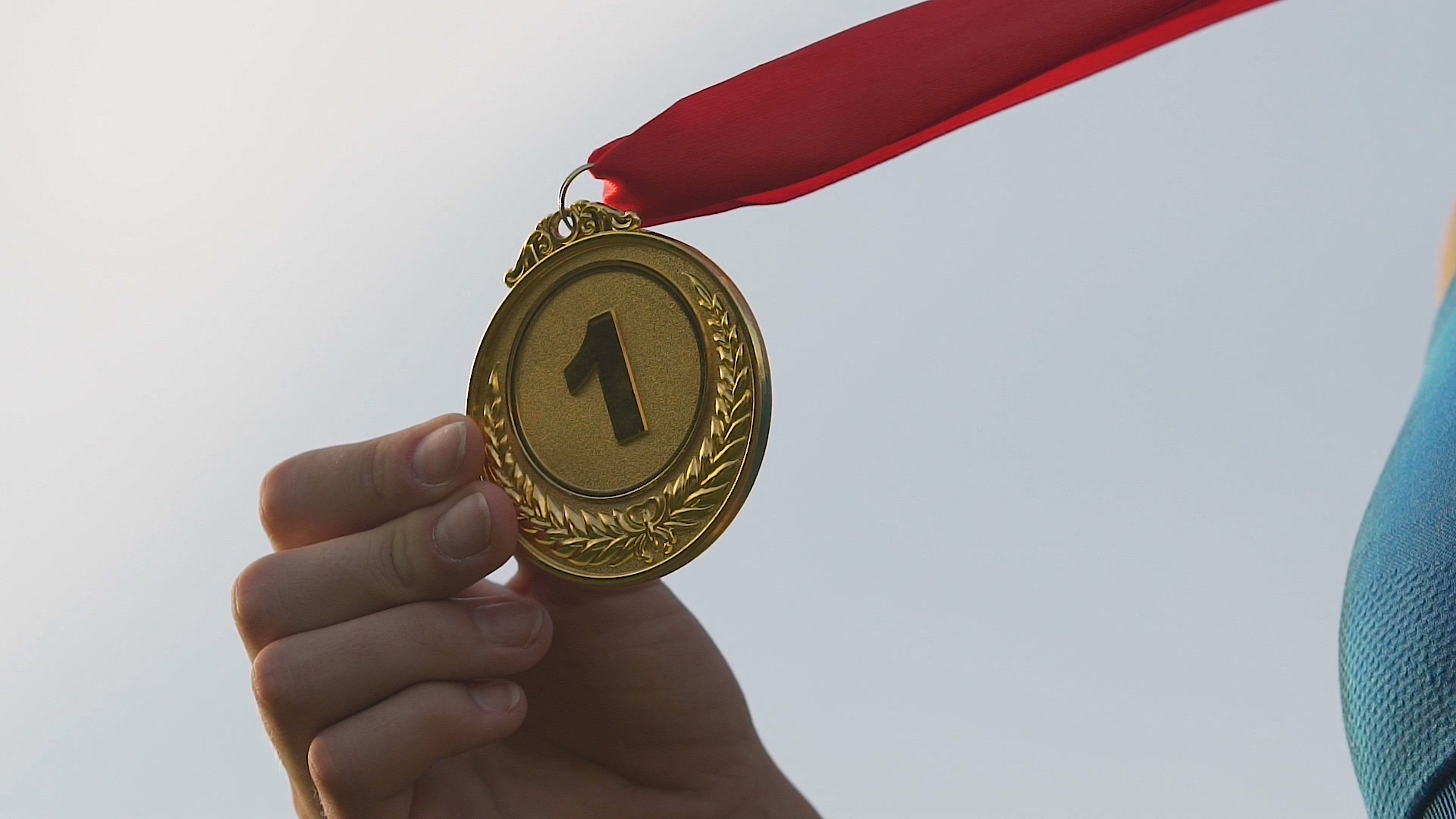 年轻女子运动员亲吻金牌– ShutterStock 1007644372